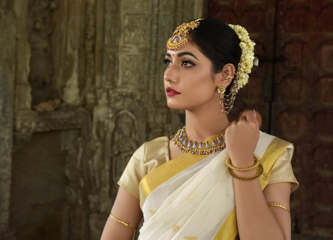 Woman in white saree with yellow border